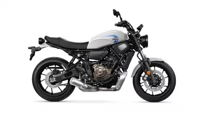 Side view of a white Yamaha motorcycle with black frame and exposed engine on a white background