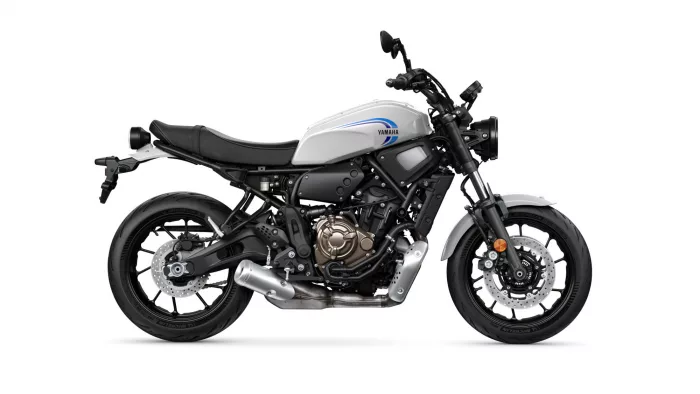 Side view of a white Yamaha motorcycle with black frame and exposed engine on a white background
