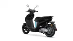 Black Yamaha NEO'S scooter photographed from the left-rear side, showing sleek body, rear wheel, and blue accent panel.