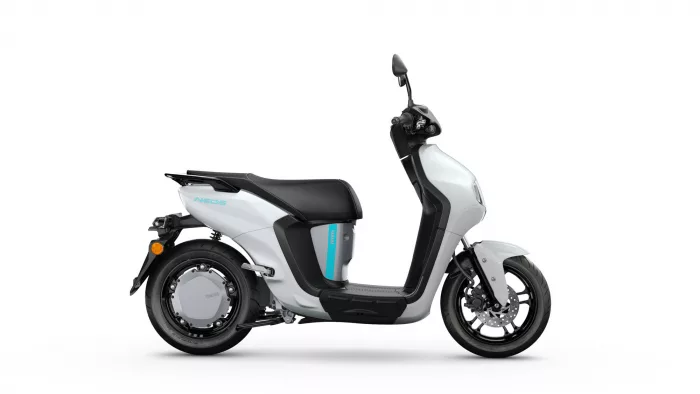 Side view of a silver and black Yamaha scooter with blue accent, showing the left side and drivetrain details