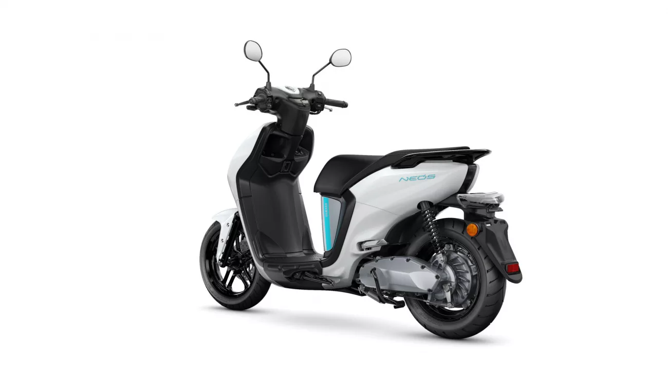 White and black scooter shown from a rear-left angle, exposing the rear wheel and seat area (informative product image).