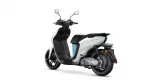 White and black scooter shown from a rear-left angle, exposing the rear wheel and seat area (informative product image).