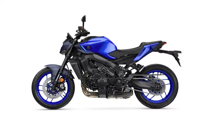 Side view of a blue and black sport motorcycle, showing engine, frame, and rode-wheel details against a white background on the left side of the frame.