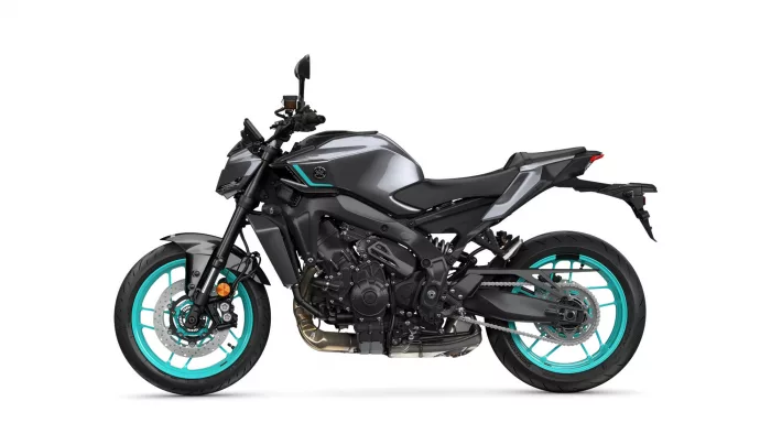 Side view of a modern sport motorcycle with teal rims and a gray-black body, showcasing its exposed engine and sleek design.