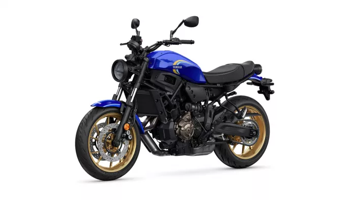 Blue Yamaha sport motorcycle shown from a front-left angle, highlighting the headlight, handlebars, and gold alloy wheels.
