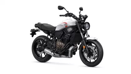 White Yamaha motorcycle shown from a front-side angle, highlighting the fuel tank with red Yamaha logo and round headlight.