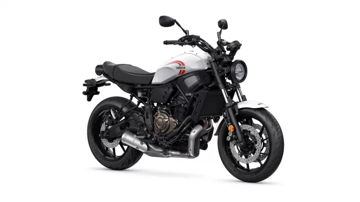 White Yamaha motorcycle shown from a front-side angle, highlighting the fuel tank with red Yamaha logo and round headlight.