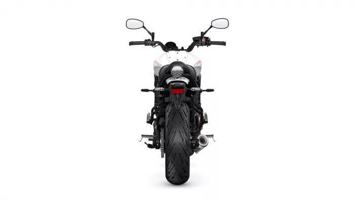 Rear view of a white motorcycle showing the taillight, license plate area, and wide rear tire on a white background.