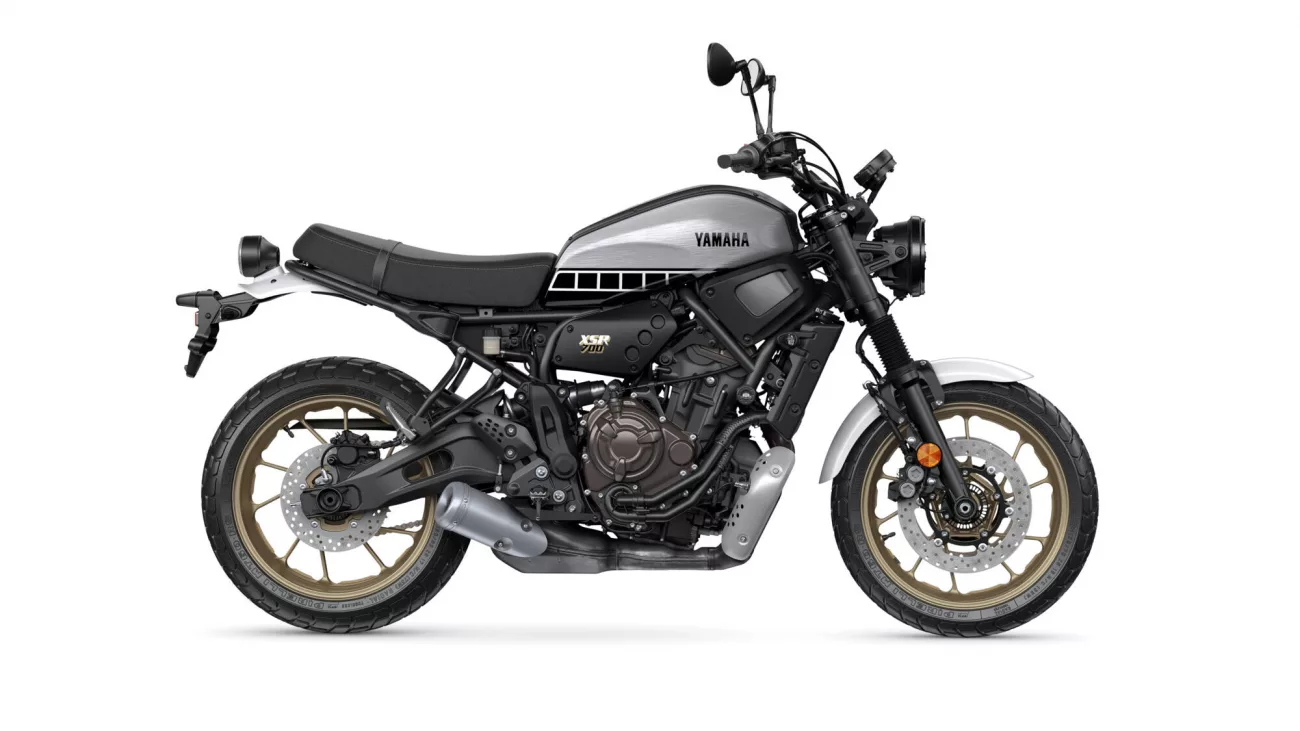 Side view of a Yamaha XSR700 motorcycle with a silver fuel tank and gold wheels, shown in profile.