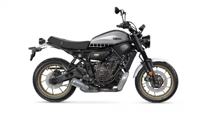 Side view of a Yamaha XSR700 motorcycle with a silver fuel tank and gold wheels, shown in profile.