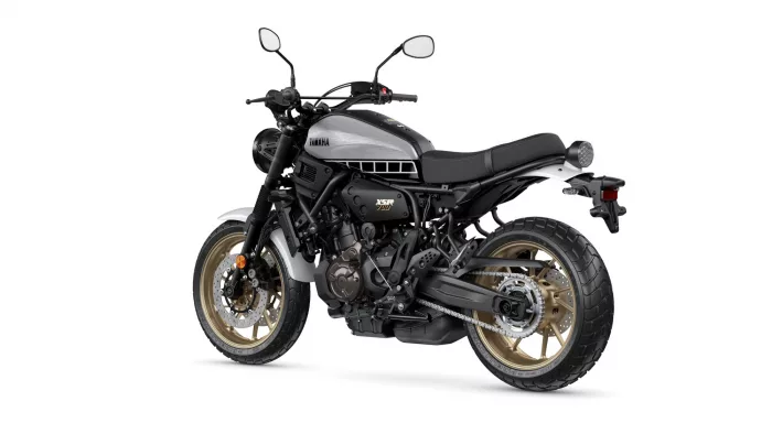 Yamaha XSR700 motorcycle photographed from a left-front three-quarter view on a white background, silver fuel tank and gold wheels visible.