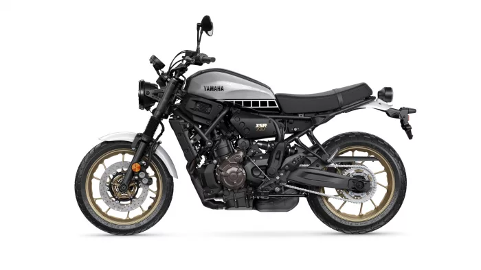 Side profile of a silver Yamaha XSR700 motorcycle with gold alloy wheels and black frame, shown on a white background.