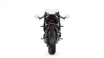 Rear view of a black sport motorcycle, showing taillight, mirrors, and wide rear tire against a white background.",