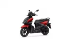 Front-left view of a red and black Yamaha scooter showing the headlight, windshield, and handlebar with mirrors