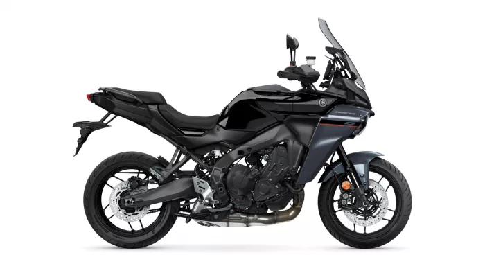 Side view of a black Yamaha Tracer sport-touring motorcycle with a tall windshield and exposed engine on a white background.