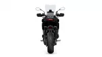 Rear view of a black motorcycle with a tall windscreen, mirrors, and a wide rear tire.