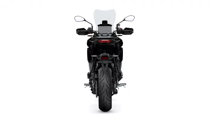 Rear view of a black motorcycle with a tall windscreen, mirrors, and a wide rear tire.