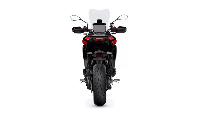 Rear view of a red motorcycle with a large clear windscreen, mirrors, and taillights visible.