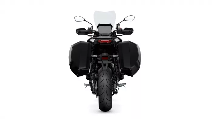 Rear view of a black adventure motorcycle with side panniers and a tall windshield on a white background