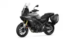 Grey sport-touring motorcycle with a tall windshield and hard side panniers, photographed from the front-left angle