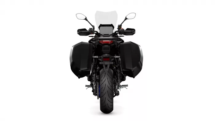 Rear view of a black adventure motorcycle with large side panniers and a tall windshield.