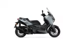 Side view of a silver and black Yamaha XMAX sport scooter with windshield and disc brakes exposed