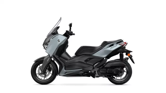 Side view of a gray Yamaha XMAX motor scooter with black accents, showing its windshield and modern styling.