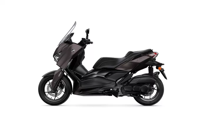 Side view of a black Yamaha XMAX motorcycle with a tall windshield on a white background, showing front wheel and body panels.