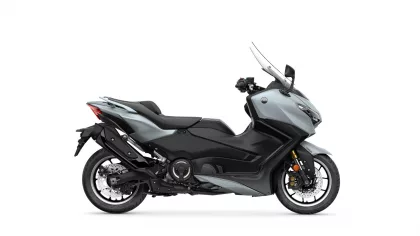Side view of a gray Yamaha sport scooter with a tall clear windscreen and black seat