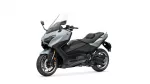 Blue-gray Yamaha Tmax sport-touring motorcycle with a tall windshield, shown from a front-left angle against a white background.
