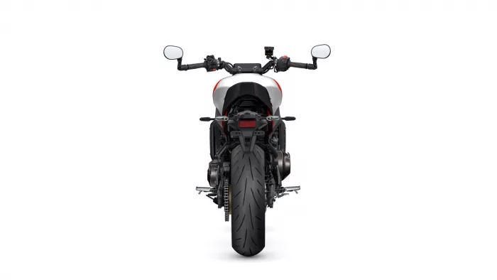 Rear view of a sport motorcycle centered on a white background, showing the thick rear tire, red-accented body, and handlebars with mirrors.