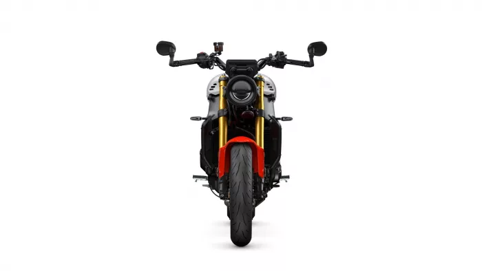 Front view of a sport motorcycle showing a round headlight, black handlebars, gold inverted forks, red front fender, and tire centered against a white background.