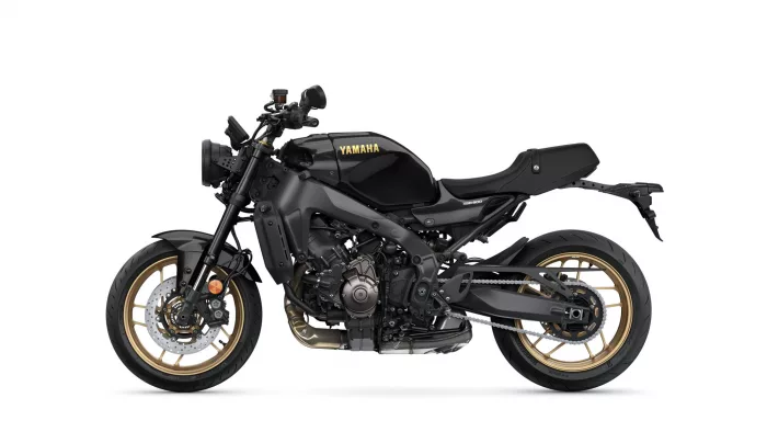 Black Yamaha motorcycle seen in profile, showing gold-rimmed wheels and sleek matte-black bodywork with 'YAMAHA' on tank (XSR900).
