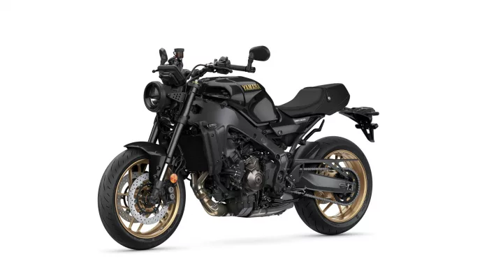 Black Yamaha XSR900 motorcycle shown from the front-left side with a matte black body and gold wheels.