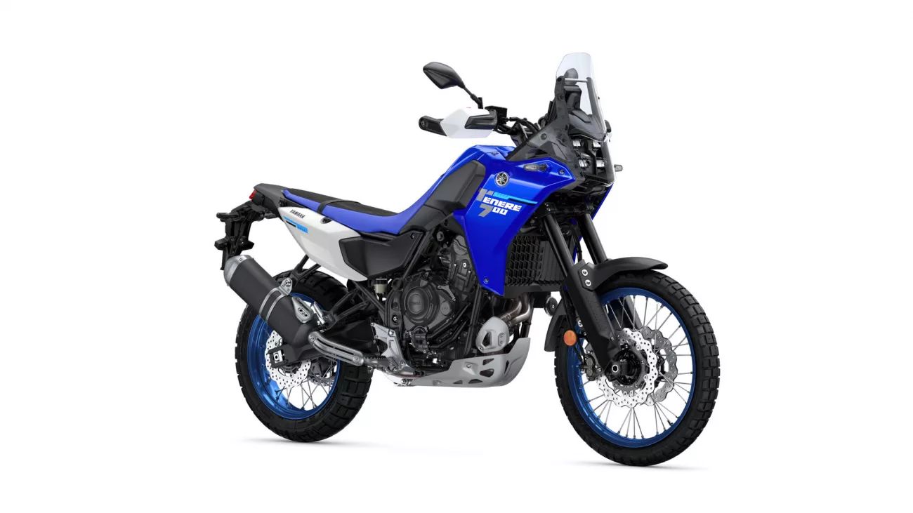 Blue Yamaha Tenere 700 adventure motorcycle shown from a left-front angle with windshield, knobby tires and exposed engine on a white background.
