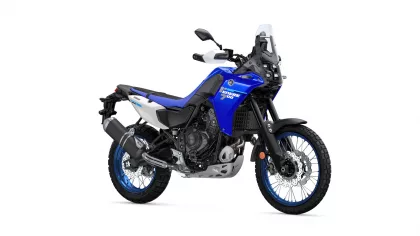 Blue Yamaha Tenere 700 adventure motorcycle shown from a left-front angle with windshield, knobby tires and exposed engine on a white background.