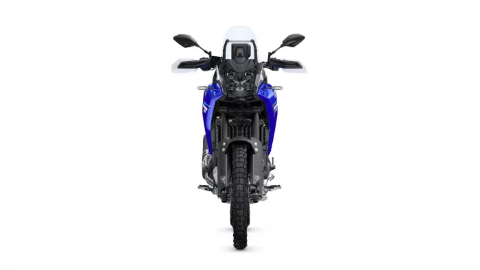 Front view of a blue adventure motorcycle with a windshield and rugged tires facing the camera.