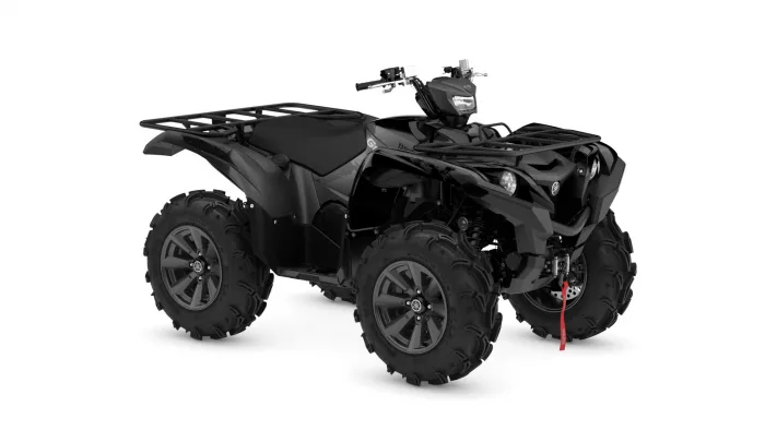 Black four‑wheeled ATV with front and rear cargo racks, large knobby tires, and a red tow strap hanging from the front.