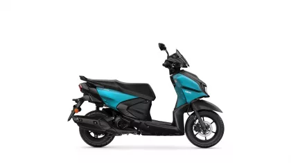 Turquoise and black Yamaha scooter viewed from the side, showing seat, exhaust, and front wheel.
