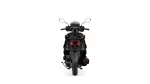 Rear view of a black motorcycle photographed from behind, showing red taillight and two side mirrors against a white background.