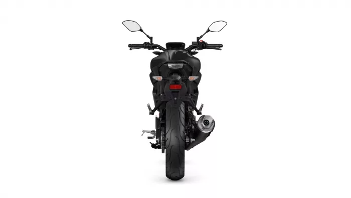Rear view of a black sport motorcycle showing tail light, turn signals, and exhaust on the right side, against a white backdrop