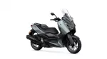 Grey Yamaha XMAX scooter shown from a three-quarter front angle with a tall clear windshield and black trim.