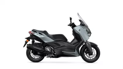 Side view of a gray and black Yamaha XMAX scooter with a tall windscreened fairing.