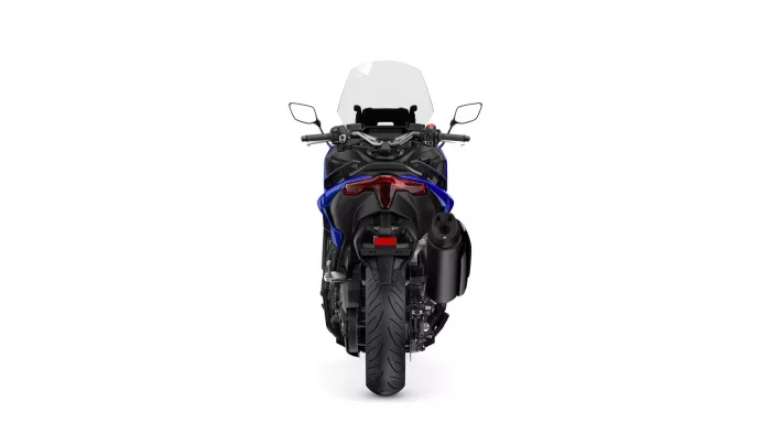 Rear view of a blue and black sport motorcycle with a tall windshield and taillight, standing upright.