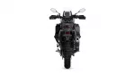 Rear view of a black adventure motorcycle with a tall windscreen, mirrors, taillight, and chunky rear tire.