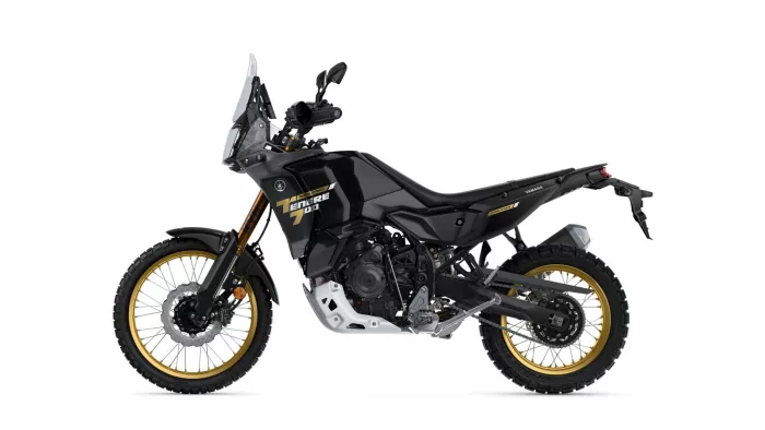 Side view of a black Yamaha Tenere 700 World Raid off-road motorcycle with gold rims and rugged windscreen