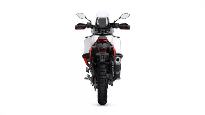 Rear view of a white adventure motorcycle with red accents, tall windscreen, and off-road tires seen from the back.