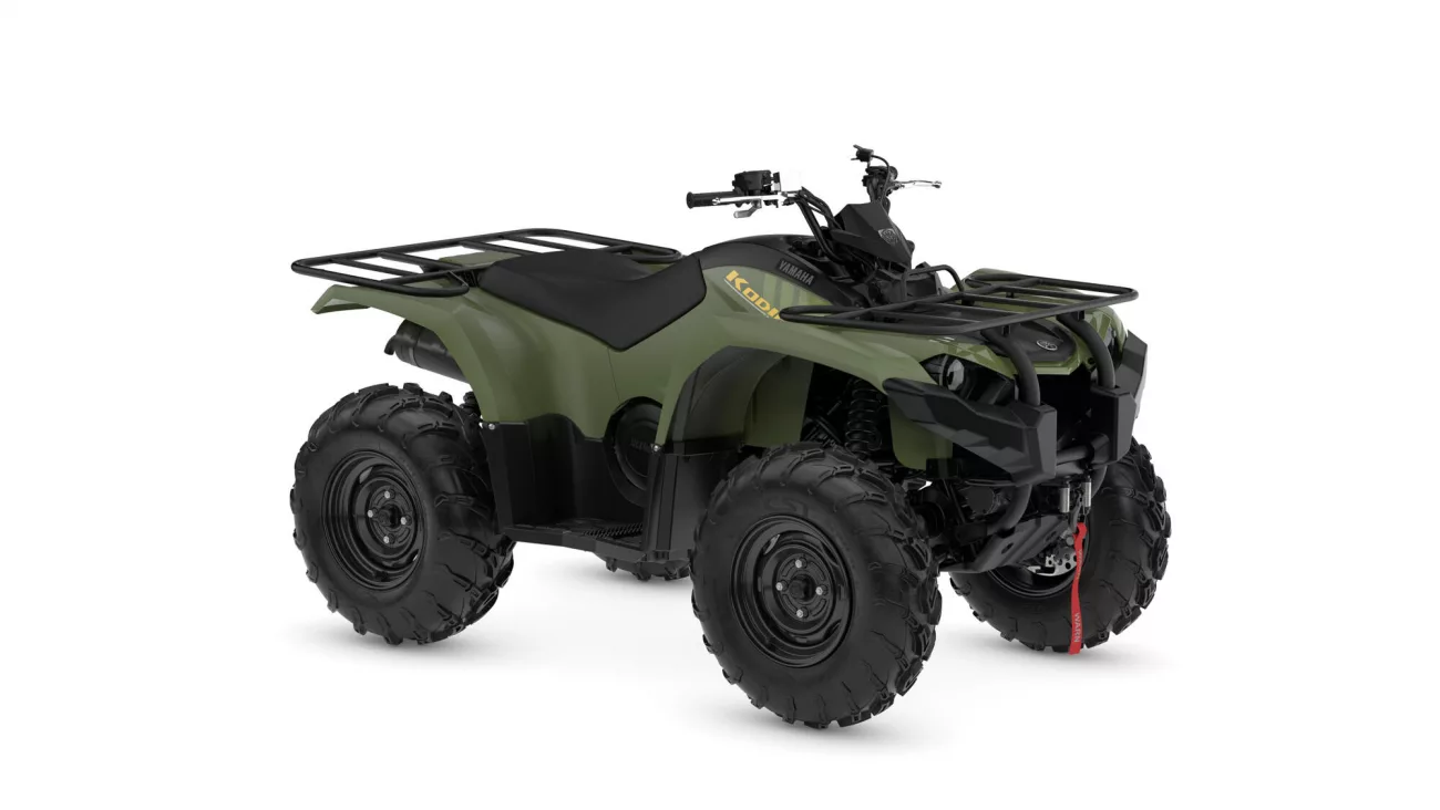 Green Yamaha Kodiak ATV with large knobby tires and front/rear cargo racks【0】.