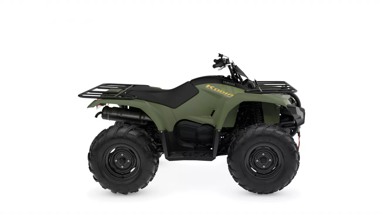 Green Yamaha Kodiak all-terrain vehicle (ATV) shown in side profile with front and rear cargo racks and chunky off-road tires