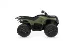 Green Yamaha Kodiak all-terrain vehicle (ATV) shown in side profile with front and rear cargo racks and chunky off-road tires